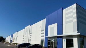 A building with cars parked in front, under a clear sky.