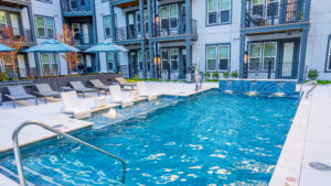 The bright blue pool which is surrounded by the apartment walls