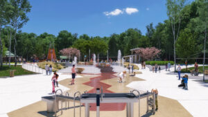 A side view of children playing in the water-playground. Water fountains are in the foreground.