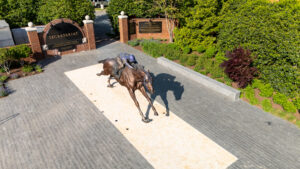 A large statue of a man riding a horse outside a gate.