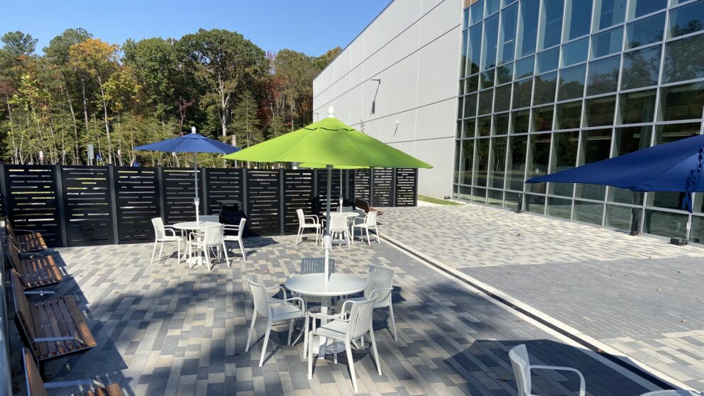 The patio on the side of the Feed More Headquarters, specifcally one table with chairs under an umbrella