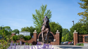 A large statue of a horse outside a gate.