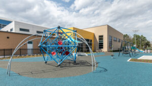 A piece of playground climbing equipment with the Southside Community Center in the background.