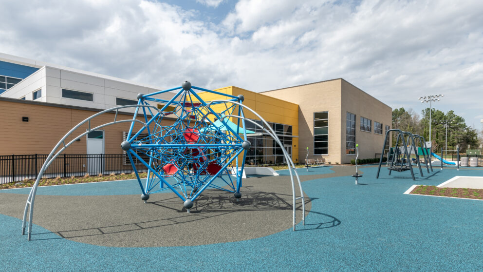 A piece of playground climbing equipment with the Southside Community Center in the background.