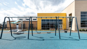 A set of swings with the Southside Community Center in the background.