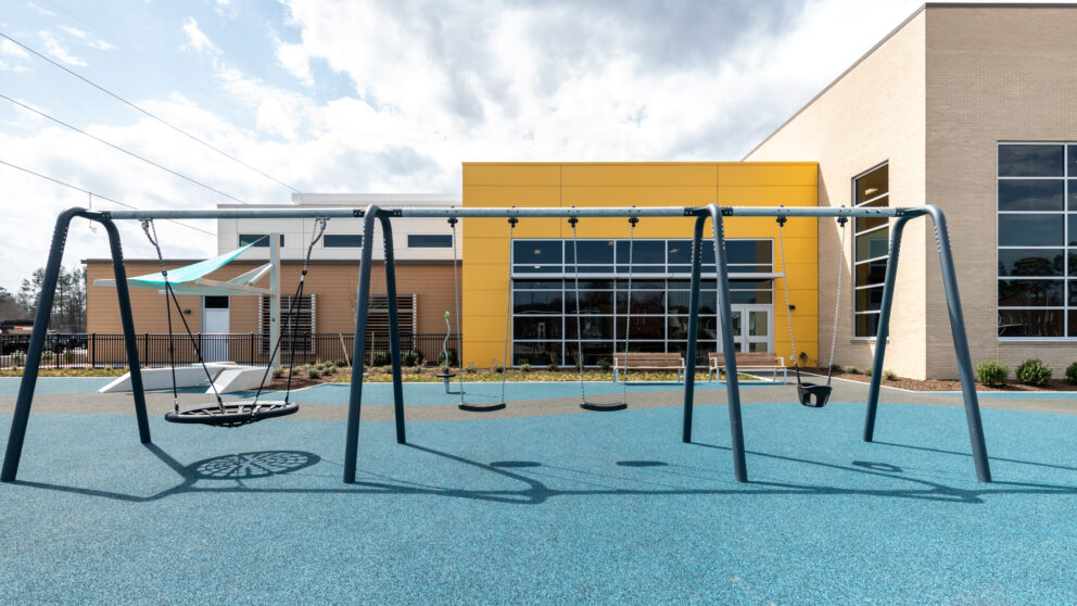 A set of swings with the Southside Community Center in the background.